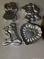 Four cake pans: princess gown, teddy bear with party hat, Ariel mermaid, fluted heart mould