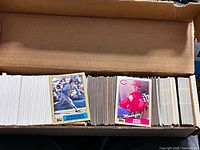 Open box showing two sample Topps cards and full rows of cards