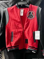 Front view of jacket showing embroidered chest patch, zipper, pockets, size and Star Wars tags