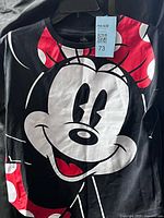 Front view of black Mickey Mouse t-shirt hanging on hanger