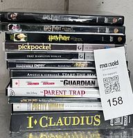 Stack of 12 DVD cases showing titles and MaxSold lot tag