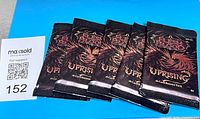 Five sealed Flesh & Blood Uprising booster packs laid out