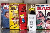 Front view of five vintage humor paperbacks on shelf