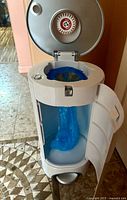 Diaper pail front with door open showing blue liner