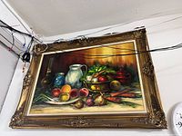 Front view of signed still life oil painting in ornate gold frame