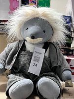 Full view of grey plush Einstein bear with clothing and tag visible