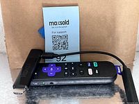 Roku streaming stick with remote and QR card visible