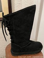 Full left side view of tall black suede boot showing overall condition and side loop details