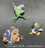 Group view of three enamel character pins