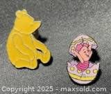 Both Pooh and Piglet enamel pins side by side