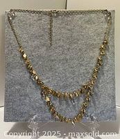 Front view of gold tone double-strand crystal necklace on display stand