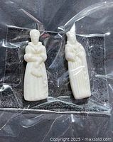 Both fève figurines inside clear packaging
