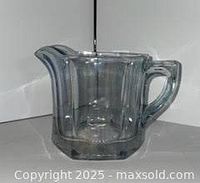 Side view of periwinkle blue pressed glass creamer pitcher showing handle and spout