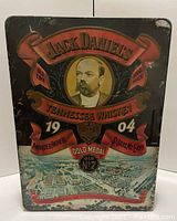 Front view of Jack Daniels advertising tin showing artwork and hinged lid