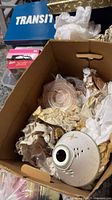 Box containing pink depression glass pieces and packed lamp parts