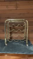 Full view of brass wheeled wine rack front