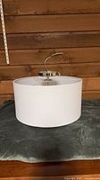 Full view of drum shade light fixture resting on surface