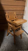 Front view of wooden doll highchair showing tray and footrest