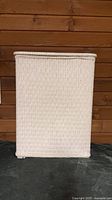 Front view of white wicker hamper