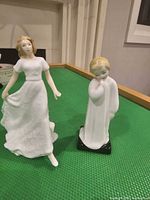 Front view of both figurines standing on green surface