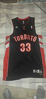Front view of black Toronto Raptors #33 jersey