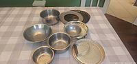 All 11 stainless steel bowls displayed on table