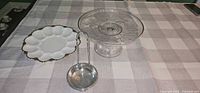 Cake stand, milk glass plate and ladle grouped on table