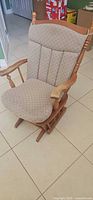 Front view of light oak glider rocking chair with beige dotted cushions