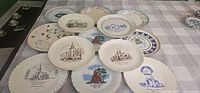All 13 decorative souvenir plates laid out to show designs and condition