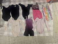 All seven leotards laid out on a checked cloth