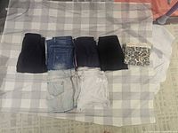 Seven folded bottoms laid out on check cloth