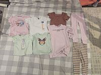 All eight clothing items laid out on bed