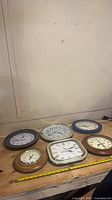 Group shot of six wall clocks on workbench
