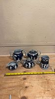 Group view of all five blue jasperware pieces with measuring tape for scale