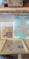 Overview of all three framed pieces: two newspapers and map