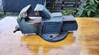 Left side view of blue cast iron bench vise showing jaws, swivel base, casting marked 80