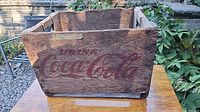 Front view showing "Drink Coca-Cola" stencil and wood grain