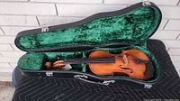 Full view of violin inside open case