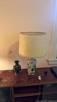 Lamp with shade and cloisonné vase on tabletop