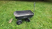 Side view of black garden wagon on grass showing overall structure