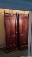Full view of pair of tall wooden cabinets