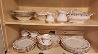 Full set on shelving showing plates, bowls, cups, saucers, serving pieces