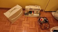 Singer sewing machine, hard cover, notions case on floor