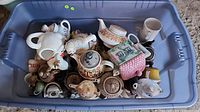 Top view of first tote showing numerous teapots of varying designs