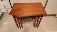 Set of three teak nesting tables stacked