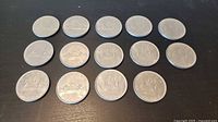 Fourteen 1968 Canadian dollar coins arranged flat, reverse side visible