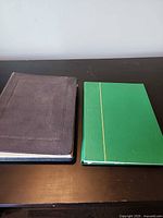 Closed black and green stamp albums