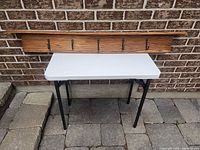 Full view of wooden coat rack on table