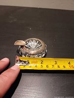 Ashtray beside tape measure showing approx 7 cm diameter