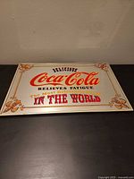 Full view of rectangular Coca-Cola mirror sign on tabletop